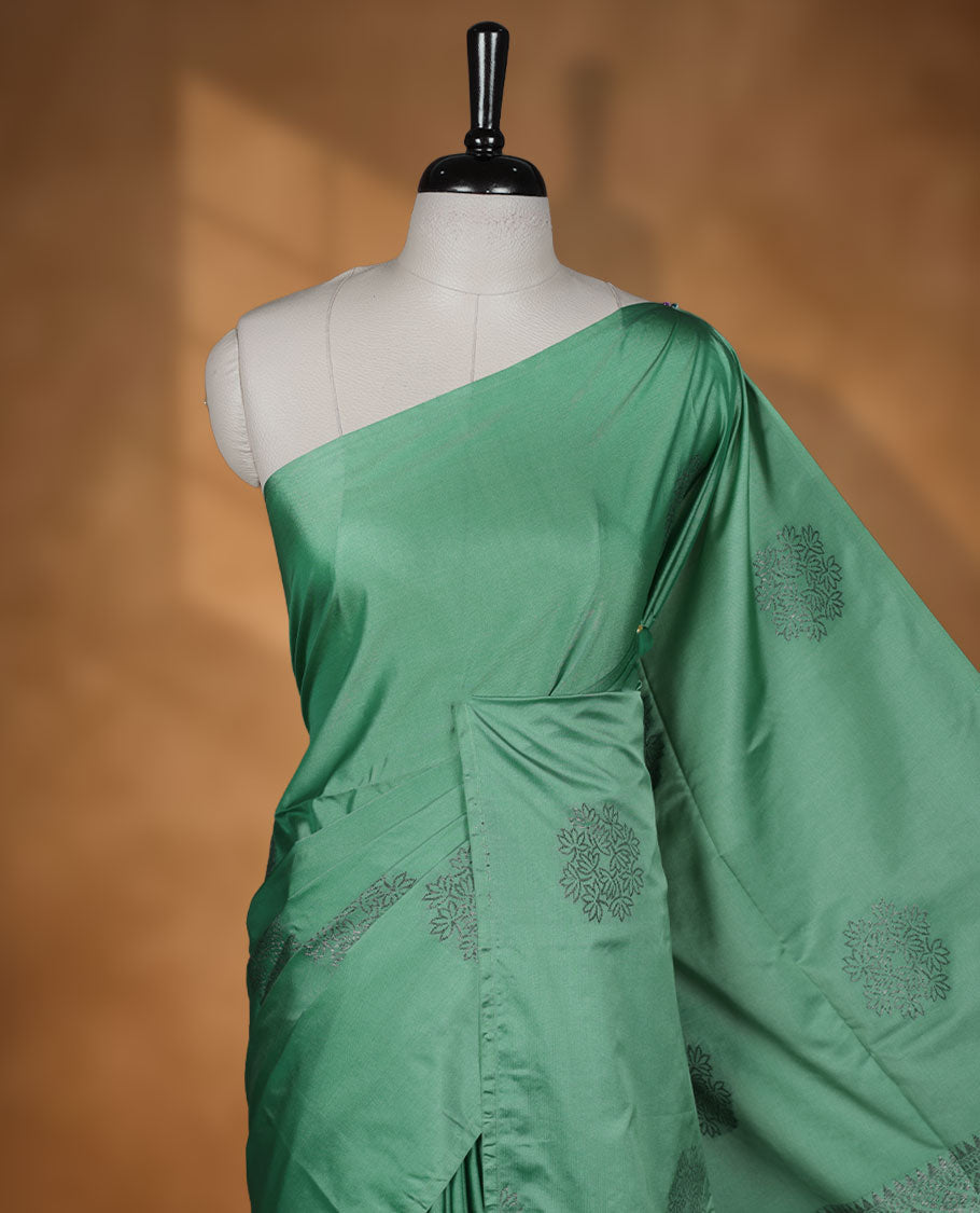 Jungle green colour semi soft silk saree adorned with delicate woven floral motifs on the body, complemented by a Self colour woven pallu with intricate detailing and tassel accents without border & Comes with a matching blouse piece.