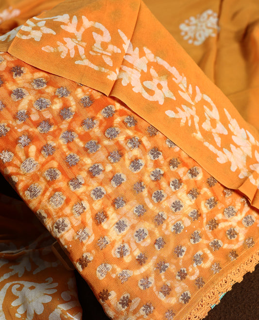 Deep yellow colour churidhar material featuring delicate floral patterns with gold highlights and bold block designs, paired with a plain matching bottom and a dupatta featuring bold white floral block prints.
