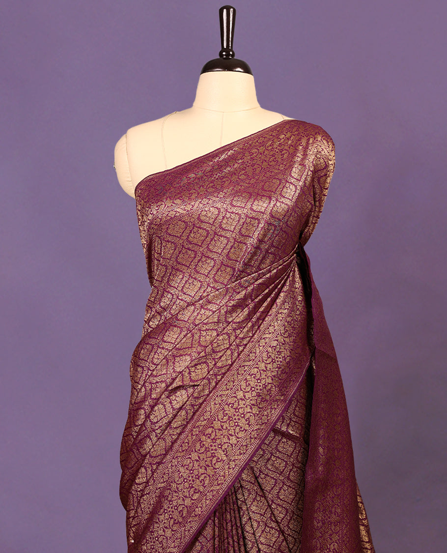 Grape colour semi Banaras Katan saree featuring an antique Gold zari jacquard body, complemented by a self colour traditional border with a floral kodi design, paired with a matching blouse