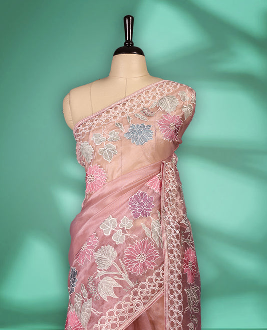 Lignt Pink colour organza designer saree featuring delicate pastel floral embroidery in pink, mint green, and white across the body, with a scalloped border accentuated by floral threadwork, and a gracefully embroidered pallu paired with matching blouse.