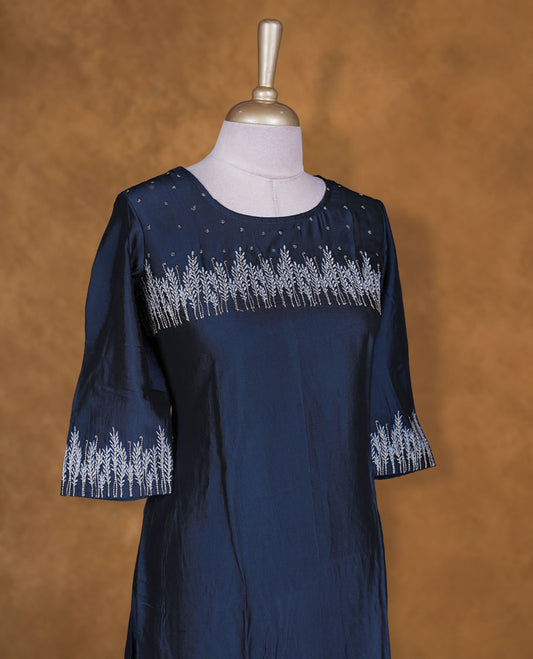 Navy blue colour kurti by Talisha with round neckline, delicate silver floral yoke embroidery and scattered motifs, A‑line calf‑length silhouette, and elbow‑length sleeves with embroidered cuffs.