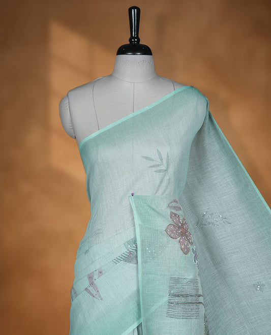 Light Blue colour Linen saree featuring Blue colour fade border with floral beats pattern around floral print across body without border, pallu and matching blouse piece.