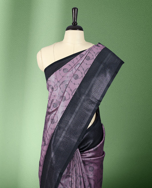 Light pastel onion colour semi silk saree featuring neem zari floral kodi motifs all over the body, complemented by a pure black woven border with geometric detailing, with matching blouse.