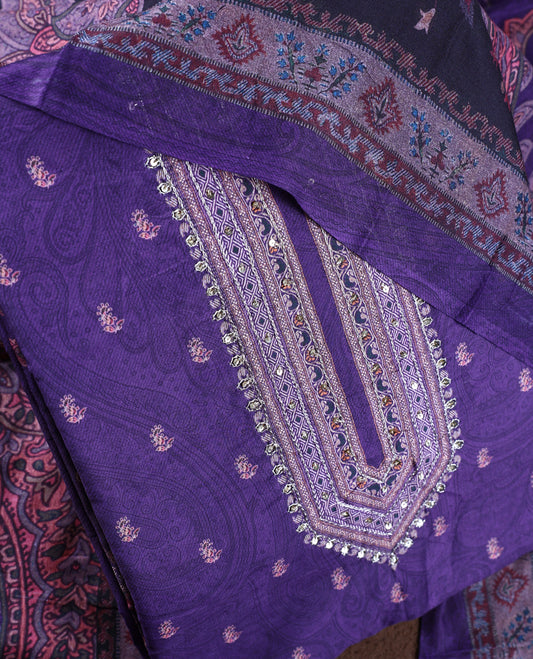 Dark lavender colour churidhar material featuring intricate paisley prints and delicate embroidery, paired with a plain matching bottom and a printed dupatta.