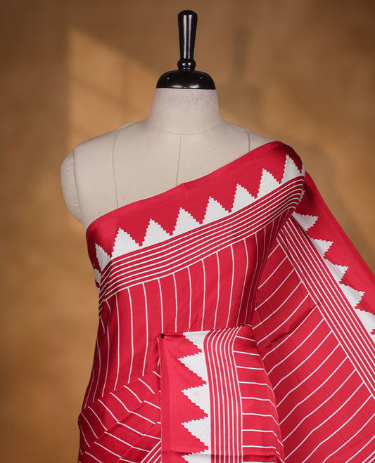 Red colour semi modal saree featuring white colour geometric borders and fine stripe detailing, finished with an oversized circular motif on the pallu, paired with a matching printed blouse.