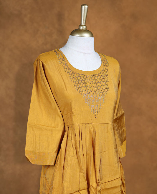 Mustard colour kurti highlighted with intricate cutwork detailing along the scoop neckline, styled with gathered waist and comfy 3/4th sleeves.