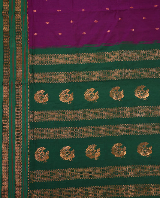 Grape and Green Kalyani cotton saree adorned with delicate buttas across the body, complemented by intricately woven golden zari patterns on the border and pallu, paired with a matching blouse