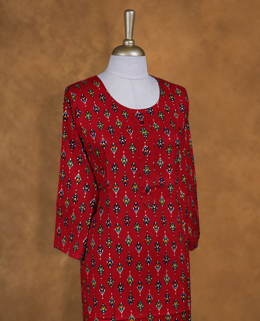 Red colour kurti styled with round neckline, multicolour pattern and gold dots on body and sleeve