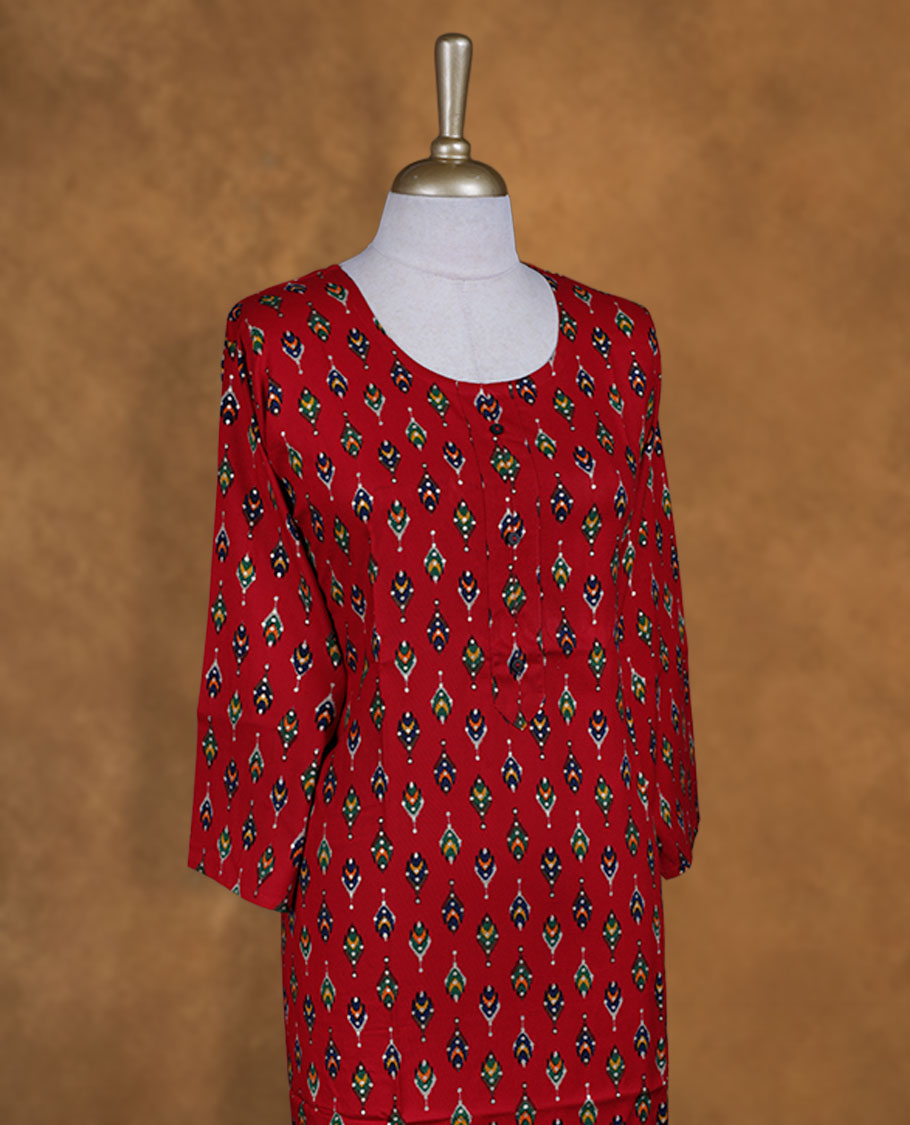 Red colour kurti styled with round neckline, multicolour pattern and gold dots on body and sleeve