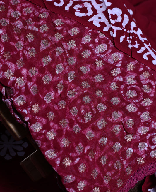 Red wine colour churidhar material adorned with gold and copper toned floral patterns and bold block designs, paired with a plain matching bottom and stylish dupatta, perfect for festive evenings and traditional gatherings.
