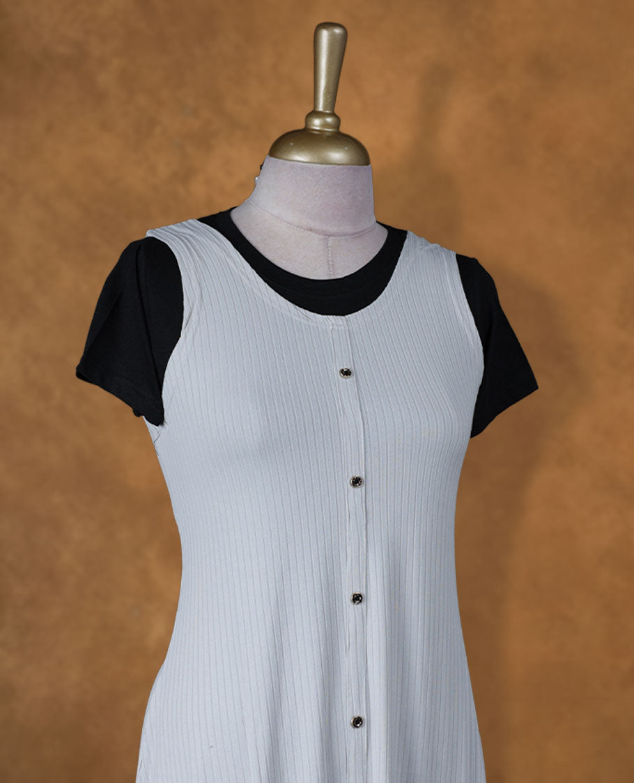 Light grey sleeveless A-line midi dress with front button detailing, layered over a black crew-neck short-sleeve inner tee.