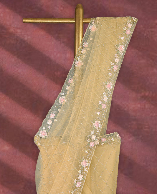 Pastel yellow colour net designer saree featuring crisscross cut beads detailing on the body, adorned with beads and sequin worked floral kodi scallop border, paired with a matching worked blouse