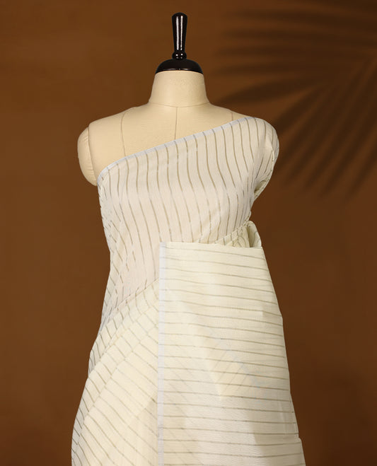 Light gold colour Organza Kerala saree featuring Silver zari stripes on the body, without border, Comes paired with a coordinated matching blouse.