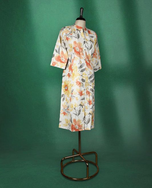 Off White colour kurti highlighted with vibrant orange, yellow, and grey floral prints, featuring a round neckline with a front slit and elbow length sleeves, cheerful and breezy pick for daytime wear.