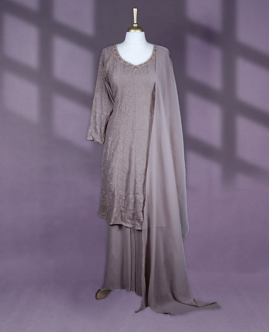 Taupe colour salwar set featuring a V neckline with subtle embellishments, three-quarter sleeves, intricate all-over embroidery, a matching chiffon dupatta, and a coordinated bottom
