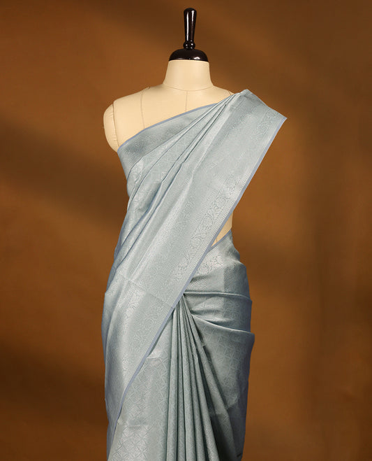 Pastel Grey coloured semi silk saree featuring a Silver coloured Zari Diamond design on the body, paired with a Self coloured border and matching blouse.