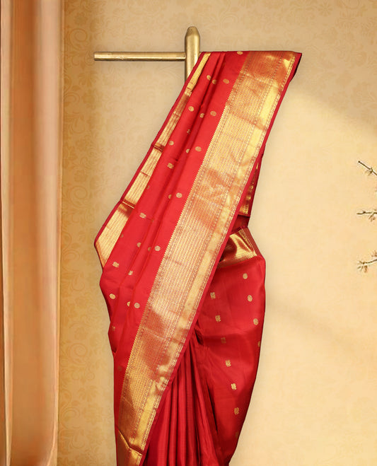 Deep red colour pure Kancheepuram traditional saree featuring gold zari Mayoora Chakra motifs across the body, enhanced with a classic traditional border and a grand pallu woven with Kuttumayil and Sayagata designs, paired with a matching blouse.