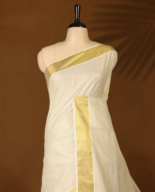 Elegant off white colour cotton Kerala saree featuring Tiny Checked body, gold zari traditional kasavu border offering a classic and graceful look, paired with a matching blouse.