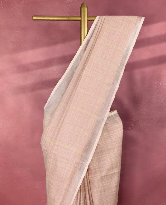 Soft blush pink colour pure linen saree featuring a striped design on the body, crafted in lightweight and breathable fabric for everyday comfort, enhanced with a simple and elegant border, paired with a matching blouse