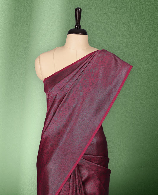 Dark Magenta colour semi silk saree featuring neem zari floral kodi motifs all over the body, complemented by a rich self colour woven border, with matching blouse.