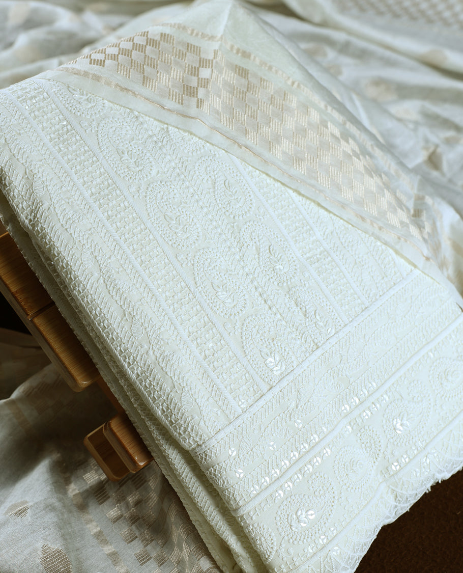 Elegant off white colour churidhar material featuring intricate woven patterns and subtle paisley embroidery, paired with a plain matching bottom and a delicately designed dupatta, perfect for timeless festive and traditional wear.