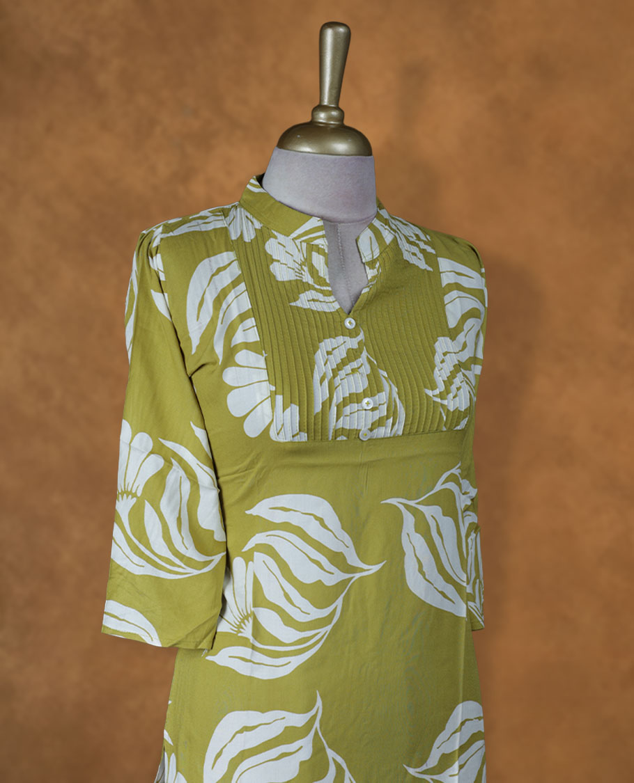 Light olive green floral printed medium-length kurti with band collar, pintuck yoke detailing, three-quarter sleeves, and straight hemline.