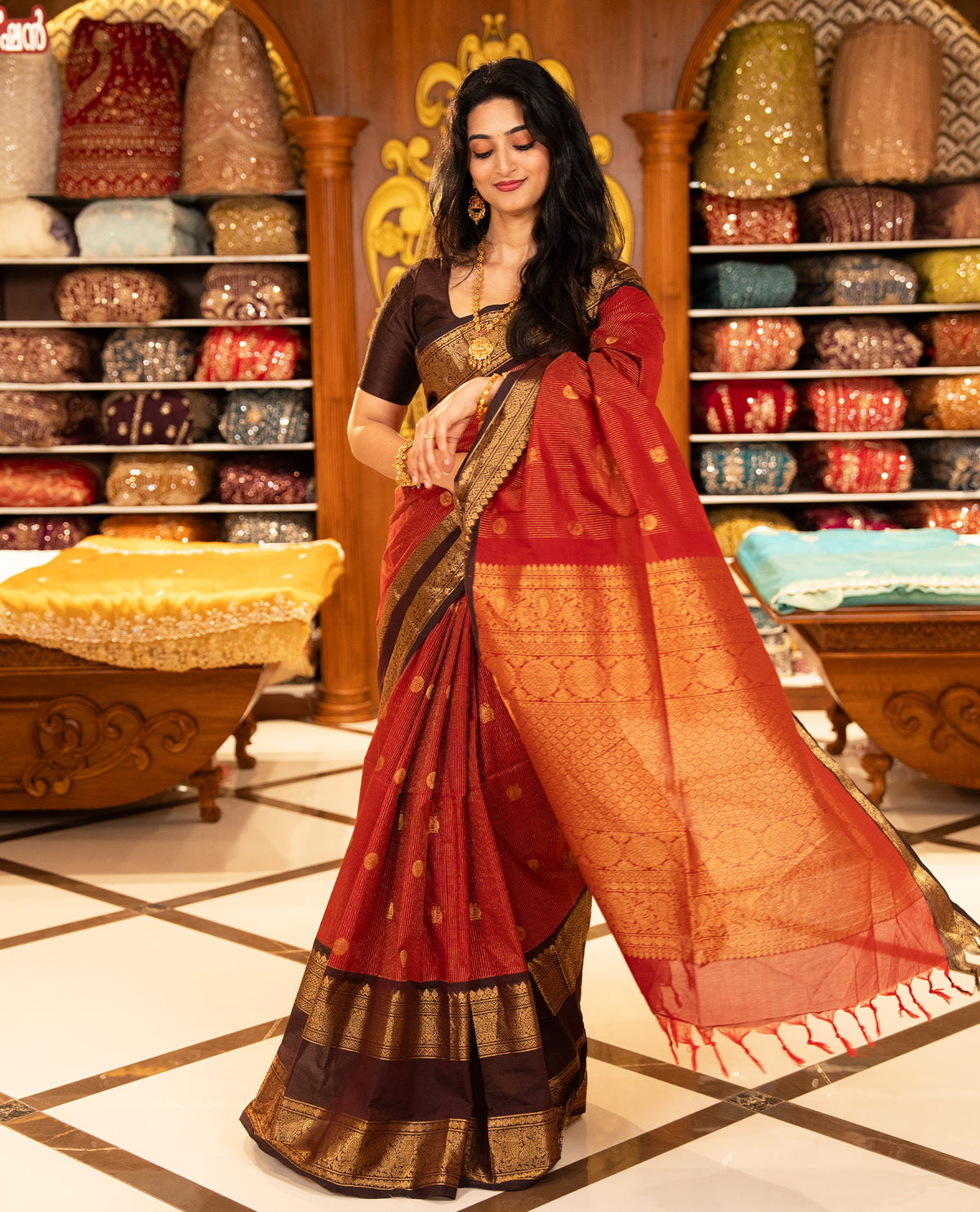 Maroon with Brown Chettinad cotton saree featuring Gold zari strips with peacock motifs on body, complemented by contrast colour border with zari design & grand pallu, comes with matching blouse piece.