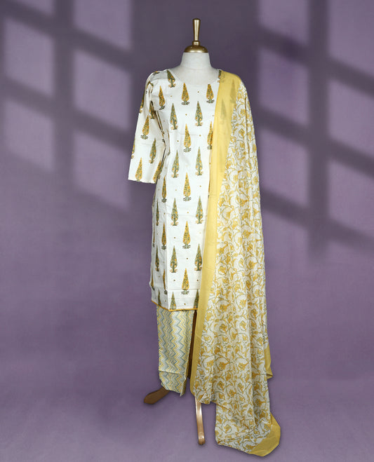 Cream colour cotton salwar set with round neck and elbow sleeves featuring green and mustard tree motifs on the kurta paired with matching zigzag bottom and yellow floral printed dupatta
