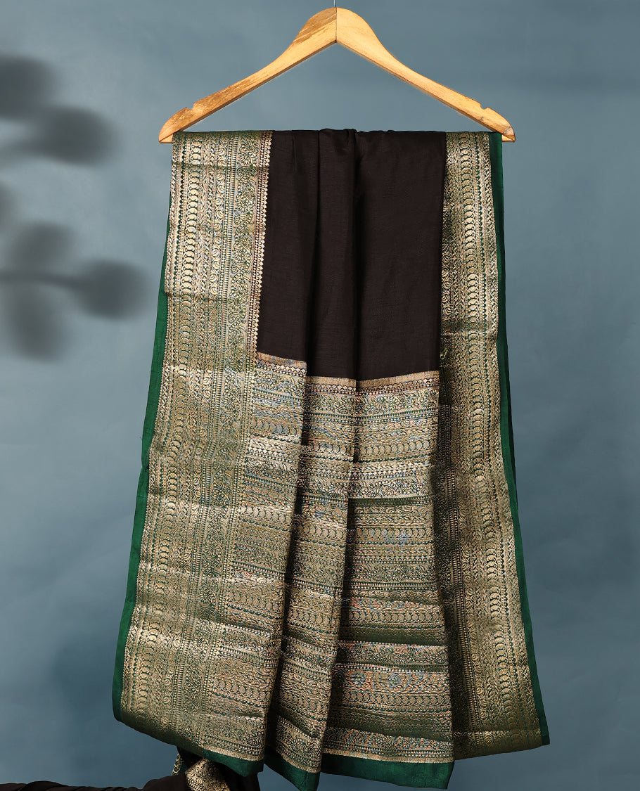 Black colour semi tussar silk saree with plain body, dark green colour traditional border, gold zari work pallu, paired with matching blouse