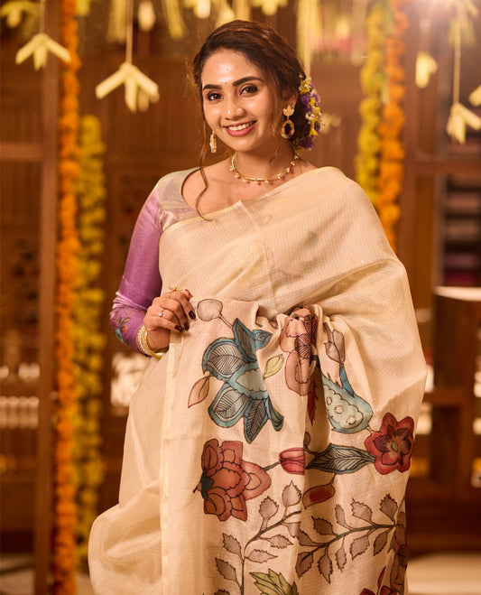 Off White colour Kerala saree beautifully adorned with Kalamkari applique floral work motifs in multicolour across the body and pallu, complemented by a subtle plain border, paired with a matching blouse