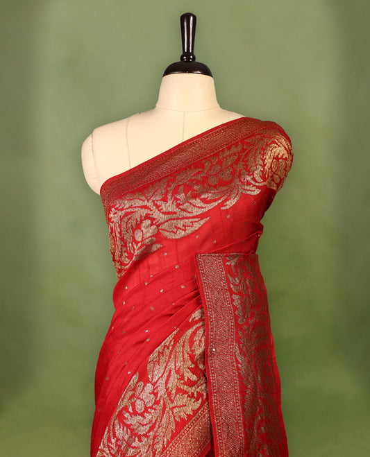 Red colour pure Tussar Banaras saree adorned with delicate golden zari motifs on the body, rich floral woven zari border and grand pallu, paired with a matching blouse for an elegant and regal traditional look.