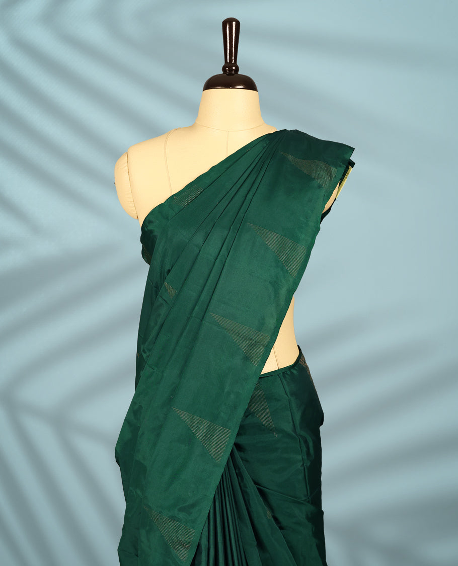 Bottle green Colour semi silk saree features a minimalistic geometric woven body design, a sleek plain border, and comes with a matching blouse.