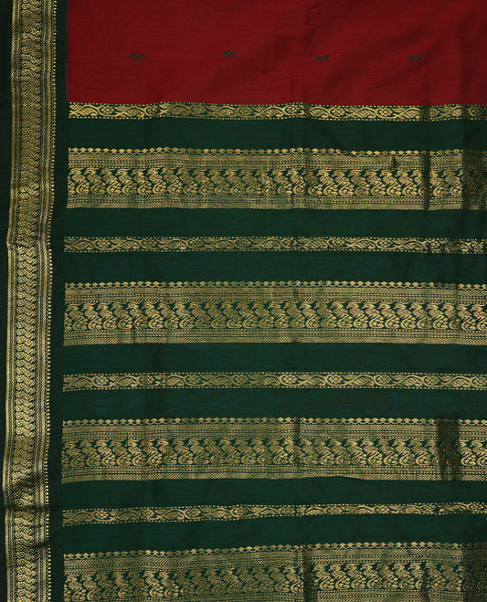 Maroon colour mixed Kalyani cotton saree featuring Green zari motifs throughout the body, paired with a Green colour traditional border and pallu, with matching blouse