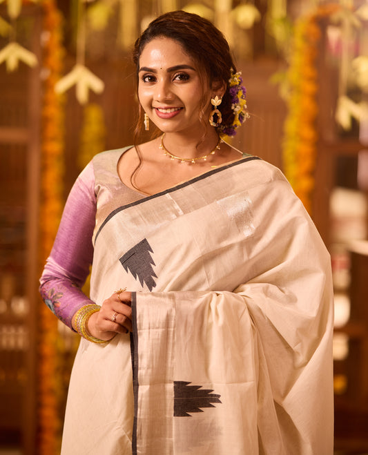 White colour Kerala Kasavu saree adorned with minimal black Temple motifs across the body, complemented by a sleek black border and zari detailing, paired with a matching blouse