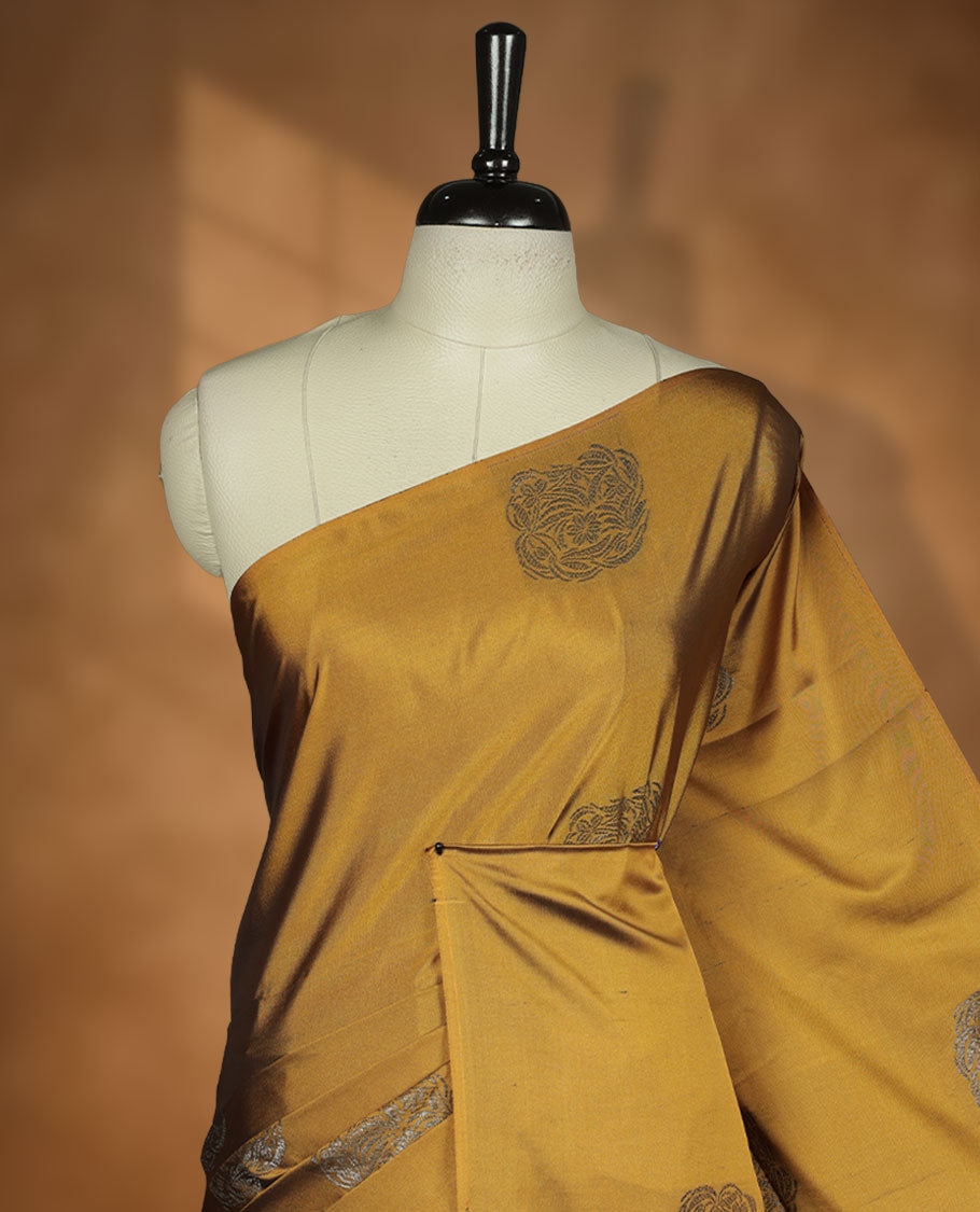 Dark mustard colour semi soft silk saree adorned with delicate woven motifs on the body, complemented by a Contrast rouge colour woven pallu with intricate detailing and tassel accents without border & Comes with a matching blouse piece.