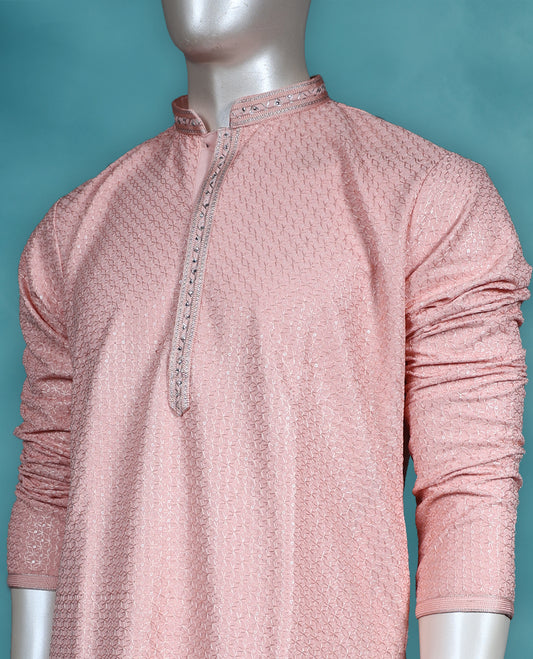 Peach colour georgette kurta set featuring self colour thread and sequin work on the body, full sleeves, and paired with a matching bottom.