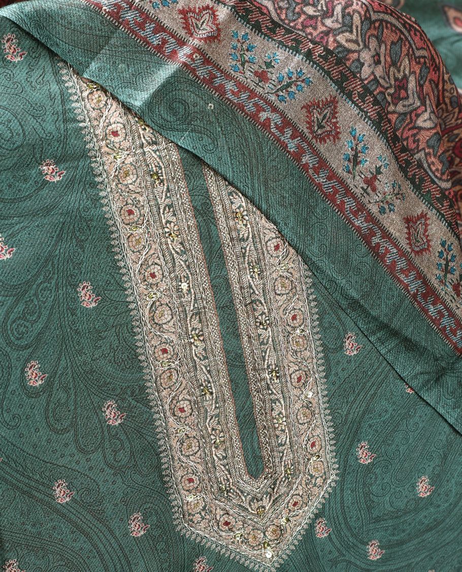 Pine green colour churidhar material featuring intricate paisley prints and delicate embroidery, paired with a plain matching bottom and a printed dupatta.