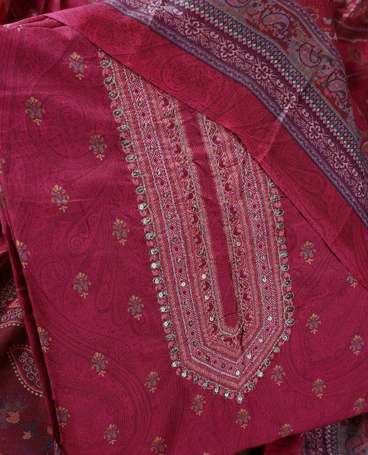 Medium maroon colour churidhar material featuring intricate paisley prints and delicate embroidery with stone highlights, paired with a plain matching bottom and a printed dupatta.