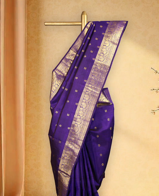 Deep violet colour pure Kancheepuram saree with gold zari Mayoora Chakra motifs on the body, traditional border featuring peacock and floral patterns, grand pallu, and paired with a matching blouse.