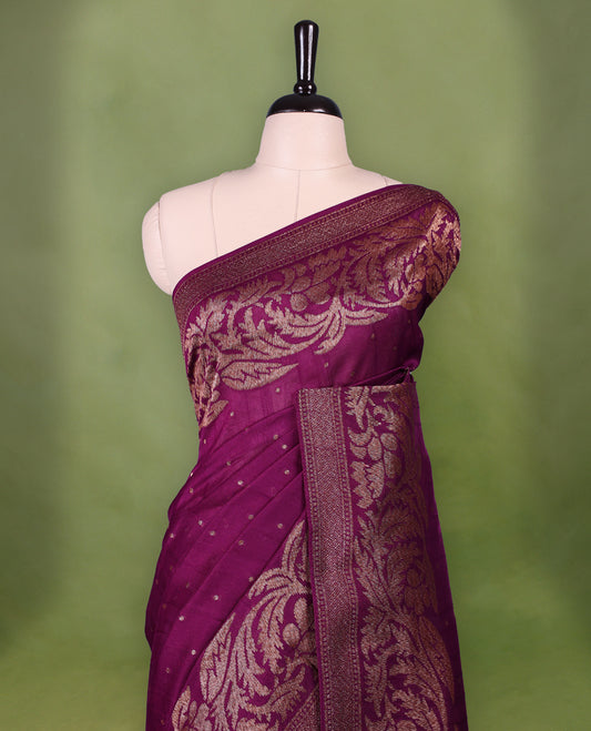 Grape wine colour Tussar Banaras saree adorned with delicate golden zari motifs on the body, rich floral woven zari border and grand pallu, paired with a matching blouse for an elegant and regal traditional look.
