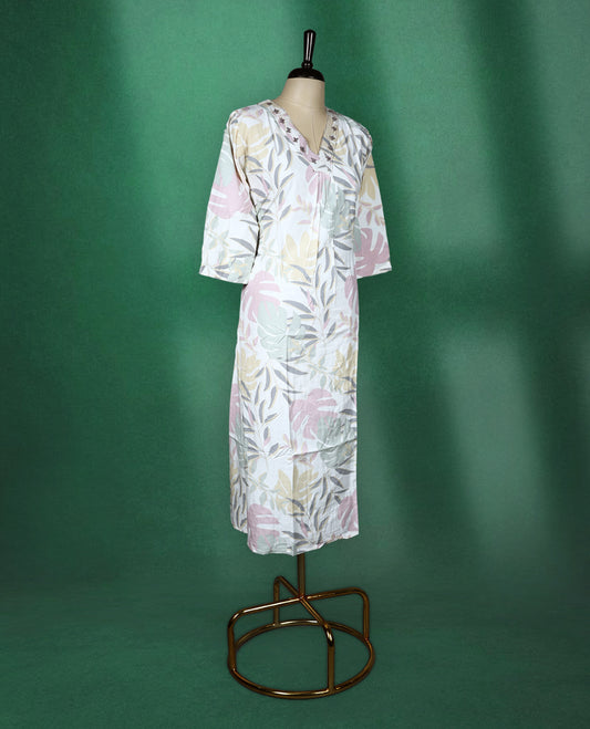 White colour kurti featuring pastel botanical prints in shades of pink, mint, and beige, designed with a V neckline embellished with delicate embroidery and finished with three quarter sleeves & soft, airy choice for effortless everyday wea