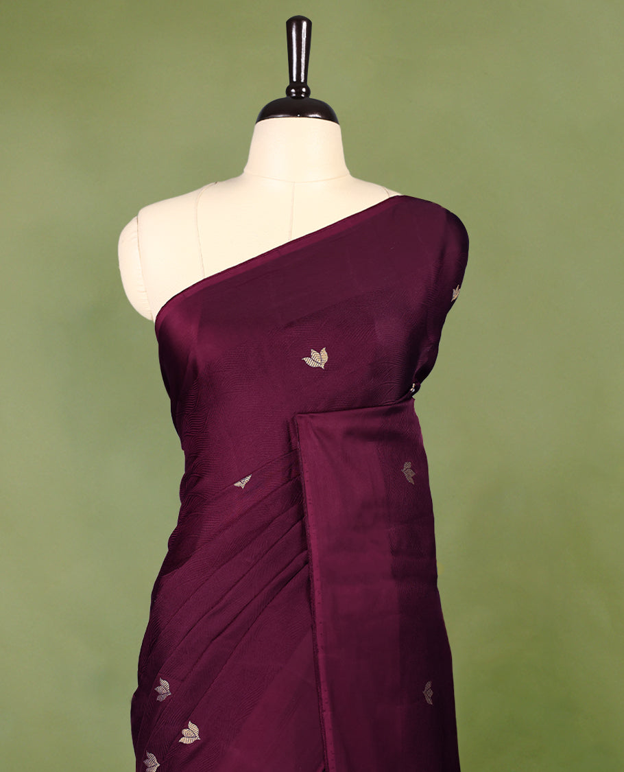 Maroon colour crepe Banaras saree featuring small zari Floral Motifs across the body, without border, a sleek texture, and a rich golden zari pallu with geometric patterns, paired with a matching blouse for a graceful festive look