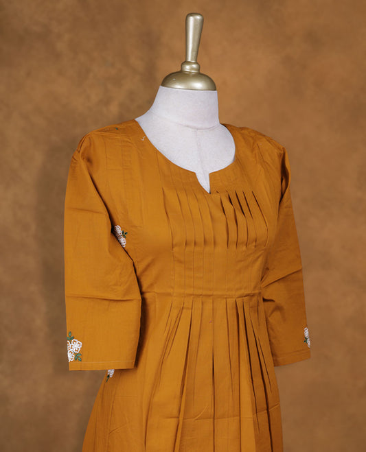 Mustard colour kurti with white colour colour thread pattern a  sleeve , knee length design, styled with a around with slit neckline and a  sleeve .