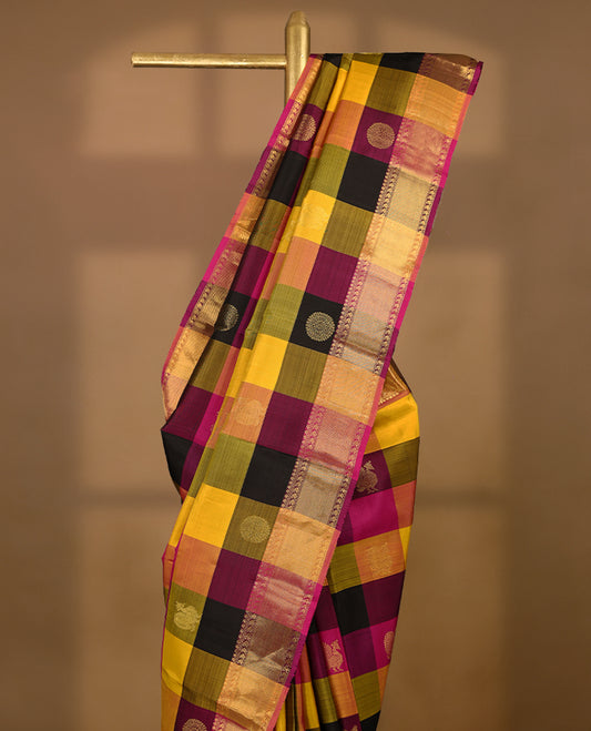 Pink, yellow, and black Checked pure traditional Kancheepuram silk saree adorned with antique zari Chakkram motifs on the body, elegantly complemented by a traditional mango design border, and paired with a matching blouse.