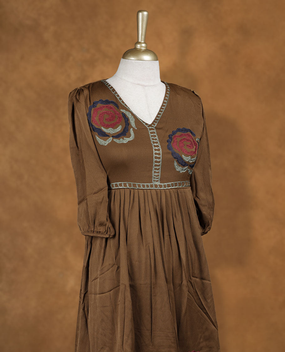 Mocha brown knee-length A-line dress with V-neckline, bold floral embroidery on yoke and hem, and elbow-length gathered sleeves.