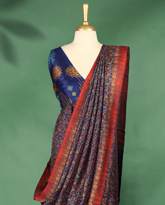 Navy blue colour Manipuri saree adorned with an all over floral pattern in multicolour hues, complemented by a rich rust-red border and matching blouse.