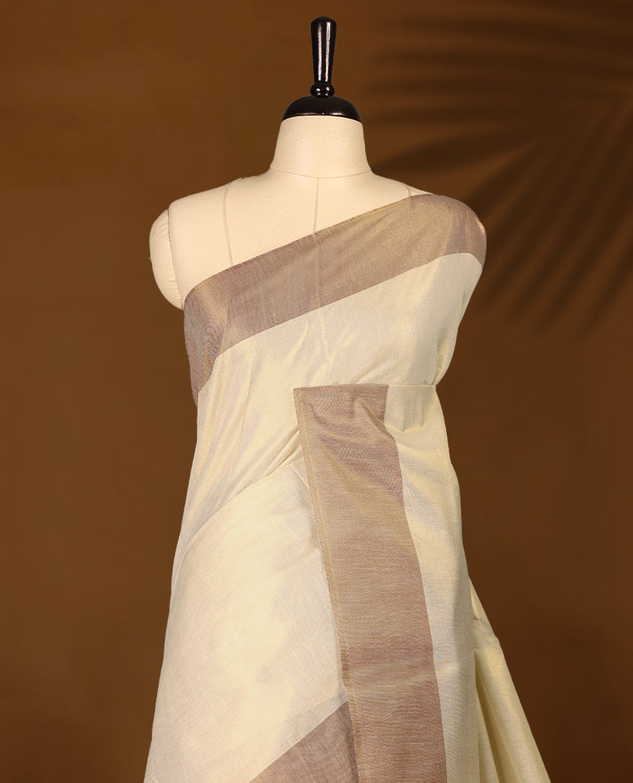 Elegant light gold Colour soft tissue Kerala saree featuring a plain body, muted Red zari border, and a striking Maroon woven checkered pallu, paired with a matching blouse.