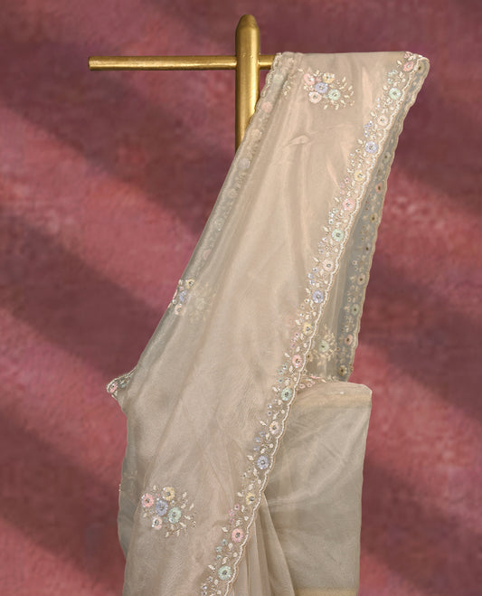 Deep beige colour pure organza saree featuring all over floral sequin work, adorned with a matching intricately worked floral border, complemented by a richly embellished pallu and paired with a heavily worked matching blouse.