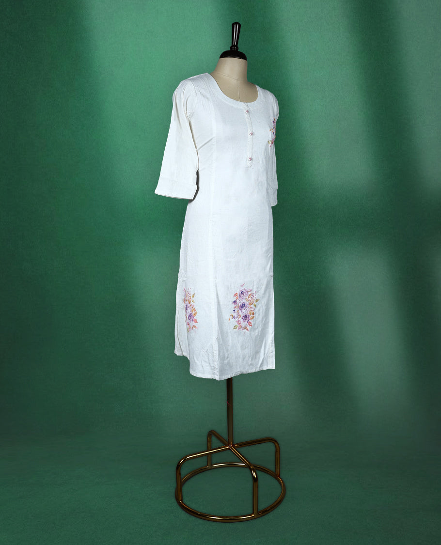 White colour cotton kurti featuring delicate floral prints in soft pastel shades with beads ans sequence work, scoop neckline with button detailing, and elbow length sleeves perfect for a graceful and breezy everyday look.
