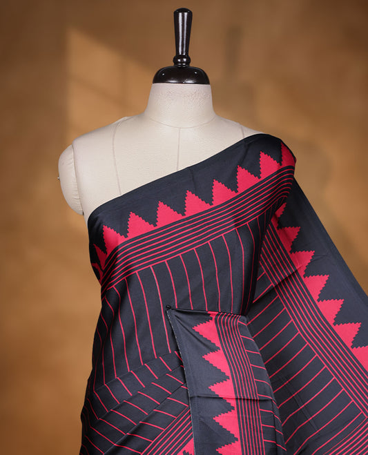Black colour semi modal saree highlighted with red triangle border accents and sleek striped detailing across the drape, featuring a bold oversized red circular motif on the pallu, paired with a matching printed blouse.